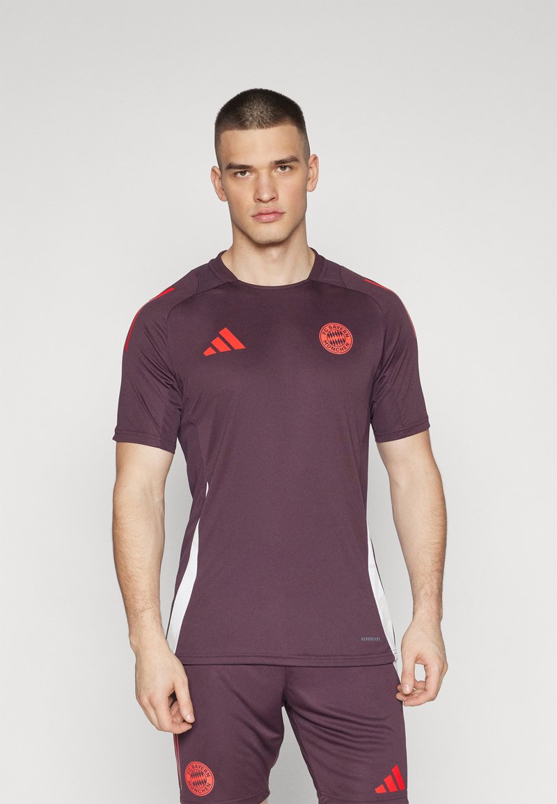 Bayern Münchens lila fotbollströja med röda detaljer, korta ärmar, rund halsringning och Adidas-logga på axlarna och shortsen.