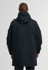 Dark navy hooded parka made of durable fabric, featuring a relaxed fit, side pockets, and adjustable drawstrings on the hood.
