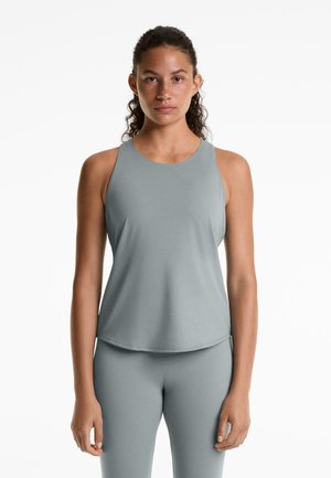 Canottiera grigia chiara con scollatura rotonda e design senza maniche, realizzata in tessuto liscio, caratterizzata da una vestibilità comoda, abbinata a un pantalone coordinato.