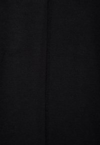 Czarna tkanina o gładkiej, teksturowanej powierzchni. Delikatne szew biegnie pionowo wzdłuż środka, wskazując na prosty, funkcjonalny design.