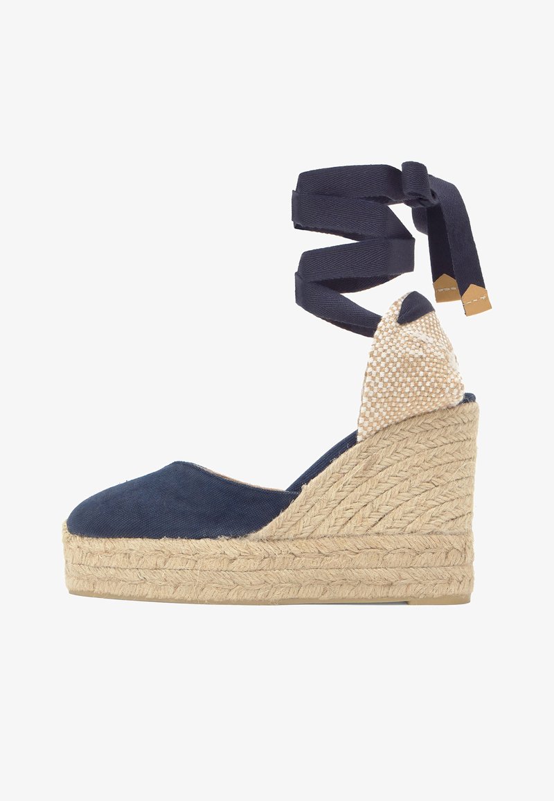 Compensée espadrille bleu marine avec semelle plateforme en jute tressé et lanières à nouer à la cheville, avec détail de talon beige à carreaux.