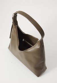 Brun skinns skulderveske med en buet design, toppglidelås og en enkel justerbar stropp. Glatt tekstur med minimal maskinvare.