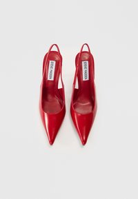 Κόκκινα slingback τακούνια από δερμάτινο πατζάρι με μυτερό σχέδιο στα δάχτυλα. Διαθέτουν λεπτό τακούνι και λεπτομέρεια με κοψίματα στις πλευρές. Μάρκα: Steve Madden.