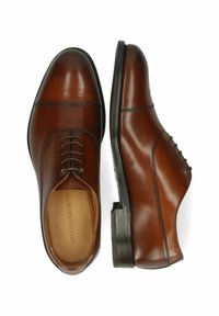 Scarpe eleganti in pelle marrone con una finitura liscia, punta arrotondata, lacci frontali e dettagli di cucitura. Tacco nero solido con texture minima.