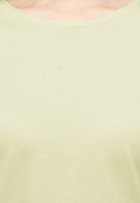 Ανοιχτόκίτρινη μπλούζα με στρογγυλή λαιμόκοψη και διακριτικό λευκό κεντημένο λογότυπο "Boss" στην μέση του στήθους.