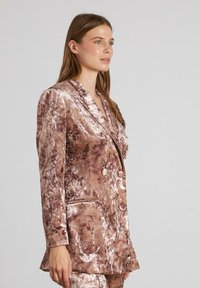 Dubbelzijdige blazer in een gemarmerde rozenbruine fluweel, met geplooide revers, twee knopen en een gestructureerd bloemmotief.