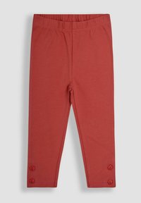Leggings per bambini color ruggine con vita elastica e due bottoni a forma di fiore vicino alle caviglie su ogni gamba.