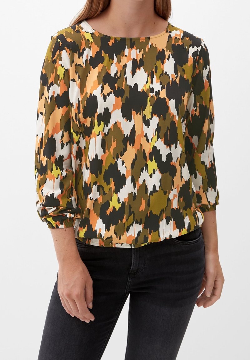 T-shirt à manches longues présentant un motif camouflage multicolore avec des teintes de vert, d'orange et de blanc ; col rond et poignets froncés.