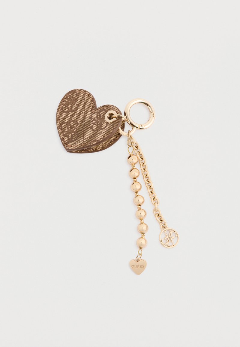 Brun hjerteformet nøglering med præget logo, guldfarvet hardware, dekorativ kæde og perler, som har en lille gravert hjertecharms mærket "GUESS."