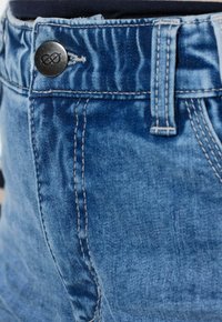 Pantalones cortos de mezclilla con un acabado azul texturizado, que presentan un botón metálico y costuras detalladas a lo largo de la pretina y las costuras laterales.