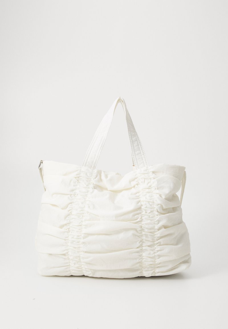 Witte tote bag van zacht, textuurstof met geplooide details en dubbele handvatten voor het dragen. Formaat ideaal voor dagelijks gebruik.