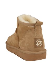 Beige Wildleder-Ankle-Boot mit einem weichen, flauschigen Innenfutter, gestickten Details und einer strukturierten Gummisohle. Enthält eine hintere Zuglasche und ein Logopatch.