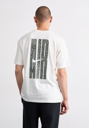 T-shirt en coton blanc avec un grand graphique en relief de couleur grise "AIR" au dos. Manches courtes et coupe décontractée.