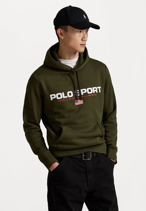 Olivegrüner Hoodie mit dem Text "POLO SPORT" und "RALPH LAUREN", Fronttasche, kombiniert mit schwarzen Hosen und einer schwarzen Kappe mit einem Logo.