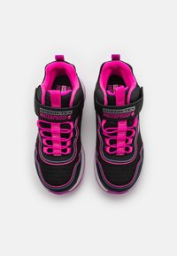 Adidași impermeabili negri cu accente roz, șireturi elastice și un upper din plasă texturată. Branding notabil pe curea și pe limbă.