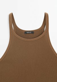 Brązowy, prążkowany top na ramiączkach z szerokimi paskami i okrągłym dekoltem, wykonany z miękkiego materiału. Metka informuje: "Massimo Dutti, wyprodukowano w Portugalii."