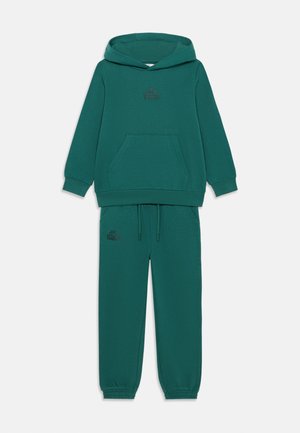 Felpa verde acqua e pantaloni abbinati in tessuto morbido. La felpa presenta una tasca a canguro, e entrambi i capi hanno un piccolo logo nero.