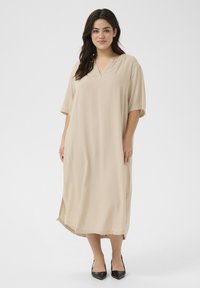 Beige, knälång klänning med V-ringning, korta ärmar och sidslitsar. Tillverkad av ett mjukt tyg, har den en avslappnad passform och minimalistisk design.