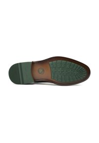 Brown leather shoe sole with green rubber bottom. Textured pattern features raised segments for traction and embossed logo in the center.