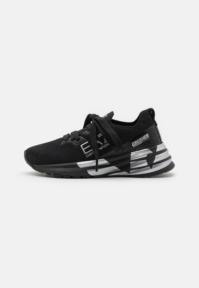 Scarpe sportive nere con una parte superiore in maglia texturizzata, accenti argento a contrasto, una suola ammortizzata e un design geometrico prominente sul lato.