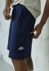Nike Sportswear CLUB CARGO - Calças de fato de treino - blau