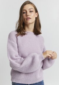 Helllila gestrickter Pullover mit gerippter Textur, lockerer Passform und weiten Ärmeln. Besitzt einen runden Halsausschnitt und einfarbiges Design.