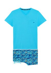 T-shirt en coton bleu vif avec un col en V et une poche poitrine, accompagné de shorts de bain bleus ornés d'un motif tropical coloré de feuilles.