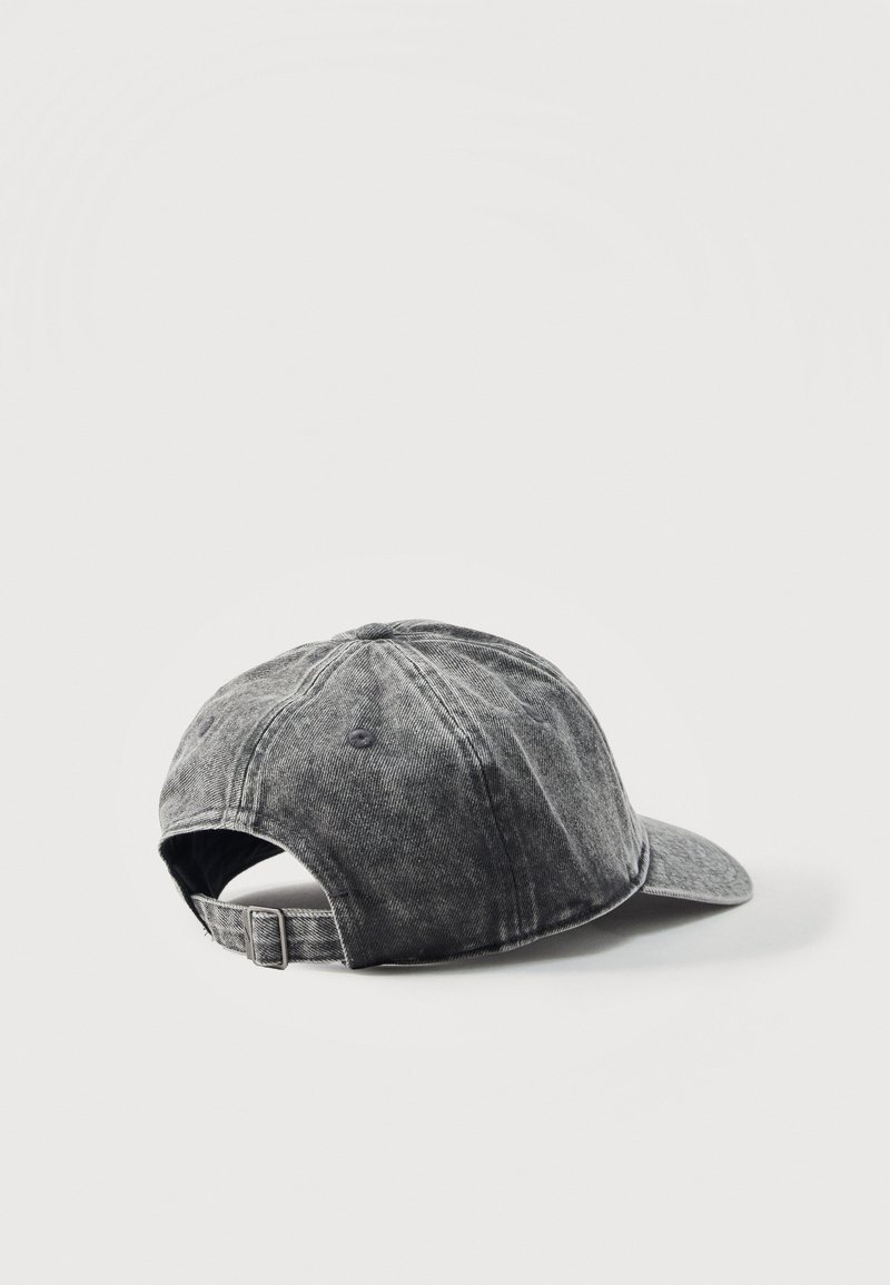Casquette de baseball en jean noir usé avec une lanière à boucle métallique réglable, vue de dos sur fond gris clair uni.