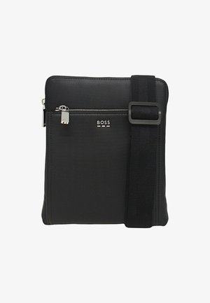Borsa a tracolla nera in nylon con tasca con zip, cinturino regolabile e hardware argentato. Presenta il logo del marchio in rilievo sul davanti.