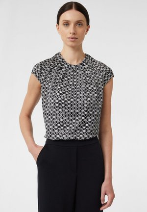 Zwart-witte geblokte blouse met korte mouwen, geplooide halslijn en zachte textuur, gecombineerd met zwarte high-waisted broek.