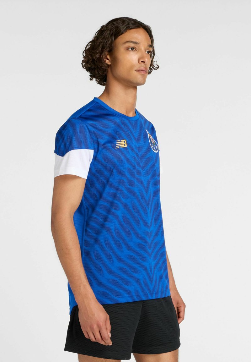 Blå atletisk kortærmet skjorte med bølgemønster, med hvid krave og ærmer samt et gyldent logo på brystet.