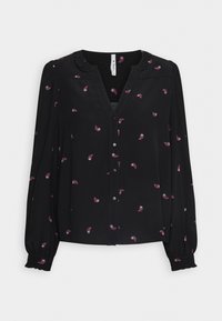 Blouse noire avec fermeture à boutons et col à volants. Présente un imprimé paisley en rose et violet, manches longues avec poignets froncés.