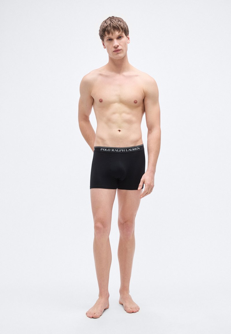 Crne bokserice od pamuka s pojasom na kojem je otisnut logotip. Standardan kroj, glatka tekstura, pružaju pokrivenost i udobnost.