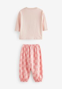 Camisa corta rosa claro de mangas cortas con cuello redondo, combinada con pantalones rosa a juego que presentan un patrón de tablero de ajedrez y una cintura elástica.