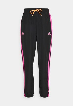 Zwarte sportbroek met roze zijstrepen, oranje trekkoord, Adidas-logo op de rechterdij en sportlogo op de linker dij.