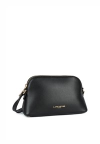 Borsa a tracolla in pelle nera con finitura testurizzata, hardware dorato e chiusura a zip. Presenta una tracolla staccabile e un logo del marchio in rilievo.