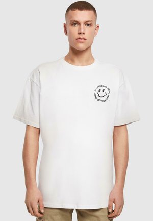 White cotton t-shirt with a loose fit, round neckline, and short sleeves. Features a black circular logo on the left chest.