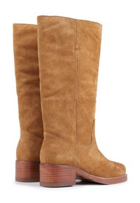 Tan suede knee-high boots with a round toe, stitched seams, and a stacked wooden heel. The surface has a soft, textured finish.