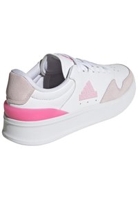 Sneaker bianco con accenti rosa, materiali in pelle e camoscio, design a basso profilo, punta rotonda e suola in gomma testurizzata. Altezza del tacco moderata.