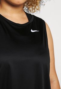 Černý sportovní top bez rukávů vyrobený z hladkého materiálu s kulatým výstřihem. Obsahuje malé bílé logo Nike na hrudi.