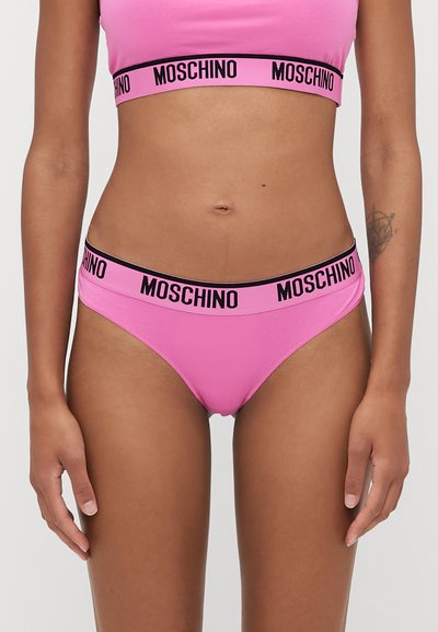 Roza bombažna spodnja perila z črnim elastičnim pasom, na katerem je napis "MOSCHINO". Srednje visok dizajn in gladka tekstura.
