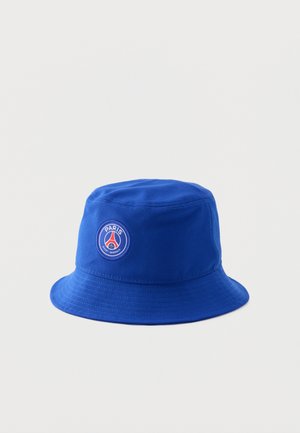 Chapeau bob bleu avec écusson du logo du club de football Paris Saint-Germain à l'avant sur un fond blanc uni.