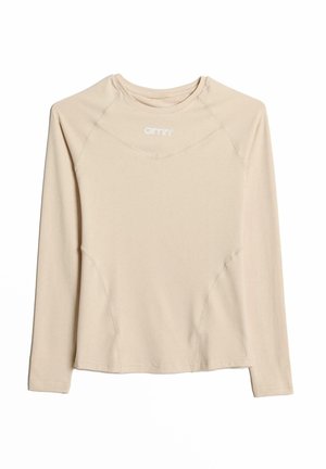 Beige langermet topp laget av myk stoff med rund hals og raglanermer, med glatte sømmer og en logo trykket på brystet.