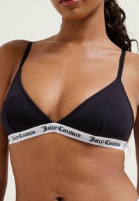 Juodas medvilninis braletė su trikampio forma, plonomis reguliuojamomis petnešėlėmis ir baltu elastingu juosteliu, ant kurio juodu šriftu užrašyta "Juicy Couture".