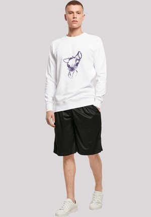Hvit hettegenser med en lilla skisse av et hjort på forsiden, paret med svarte shorts og hvite joggesko, som står på en nøytral bakgrunn.