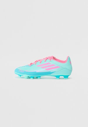Crampons de football bleu clair avec des accents roses, surface texturée, design à lacets et six pointes moulées pour une adhérence sur le terrain.