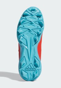 Crvena atletska cipela s potplatom s teksturiranim tirkiznim vanjskim dijelom. Ima istaknute uzorke za prianjanje i brendirani logo blizu pete.