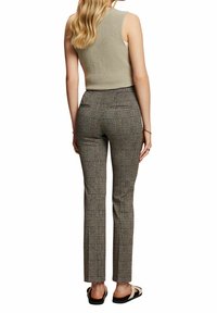 Op maat gemaakte, geblokte broek in een grijs en zwart palet, met een hoge taille, smal model en twee achterzakken. De stof heeft een gladde textuur.