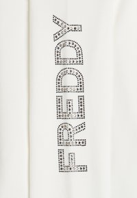 Tessuto bianco decorato con un design testuale composto da strass argentati. Le lettere sono in grassetto e giocose, creando un contrasto accattivante.