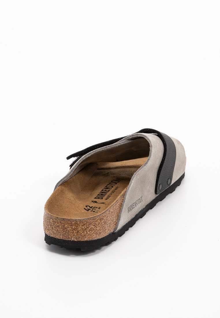 Grijze suède instap schoenen met kurken voetbed en zwarte bandaccenten. Beschikt over een gestructureerde zool en branding op de binnenzool. Maat 42.